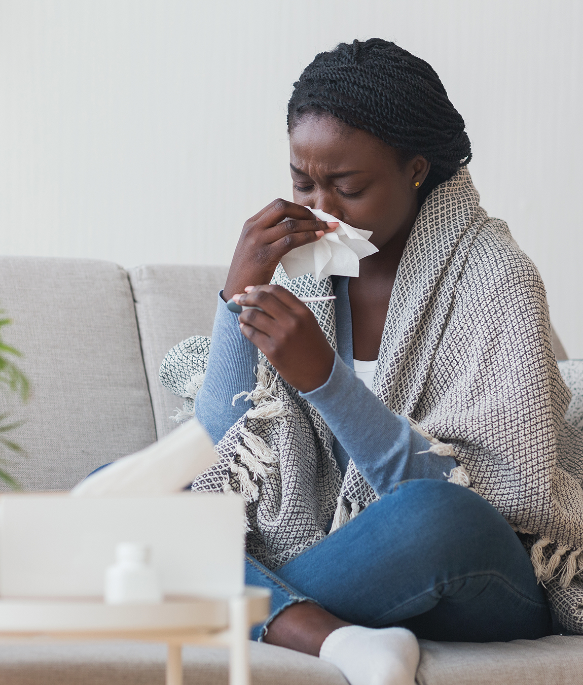 Woman with a cold blowing her nose with a tissue